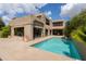 A backyard swimming pool with a patio, sliding glass doors, and lush green landscaping at 3033 E Claremont Ave, Phoenix, AZ 85016