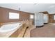 Spa-like bathroom with a luxurious tub, travertine tile, and glass block accents at 3112 N 110Th Ave, Avondale, AZ 85392