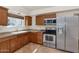 Kitchen featuring stainless appliances, tiled floors, and wooden cabinets at 3112 N 110Th Ave, Avondale, AZ 85392