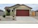 Charming single-story home featuring a two-car garage, landscaped front yard, and a welcoming entrance at 323 S San Fernando Ln, Casa Grande, AZ 85194