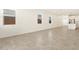 Bright, open living area with neutral tile floors, large windows, and a view towards the modern kitchen at 323 S San Fernando Ln, Casa Grande, AZ 85194