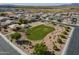 Aerial view of a community with central green space, playground, volleyball court and lush desert landscaping at 3247 N Loma Vis, Mesa, AZ 85213