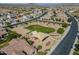 Aerial view of a community featuring a grassy common area, playground and volleyball court, amidst desert landscaping at 3247 N Loma Vis, Mesa, AZ 85213