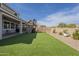 Manicured backyard with a playground, synthetic grass, and planter beds at 3247 N Loma Vis, Mesa, AZ 85213