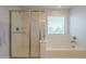 Bright bathroom with separate shower and soaking tub under a window at 3247 N Loma Vis, Mesa, AZ 85213