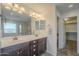 Bathroom featuring dual sinks, vanity, and access to a walk-in closet at 3247 N Loma Vis, Mesa, AZ 85213