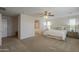 Bright, carpeted bedroom with a ceiling fan and ensuite bathroom entrance at 3247 N Loma Vis, Mesa, AZ 85213