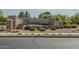 Entrance sign for Lehi Crossing featuring stone pillars, desert landscaping, and colorful flowering bushes at 3247 N Loma Vis, Mesa, AZ 85213