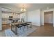 Open dining area with a chandelier, a wood table and black chairs, and a view into a modern kitchen at 3247 N Loma Vis, Mesa, AZ 85213