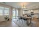 Open dining area with backyard access, modern chandelier, and a view into the kitchen at 3247 N Loma Vis, Mesa, AZ 85213