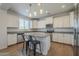 Modern kitchen features white cabinets, stainless steel appliances, a granite countertop island, and stylish pendant lighting at 3247 N Loma Vis, Mesa, AZ 85213