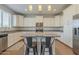 Modern kitchen features white cabinets, stainless steel appliances, a granite countertop island, and stylish pendant lighting at 3247 N Loma Vis, Mesa, AZ 85213