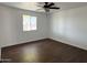 Bright bedroom with dark wood floors, a ceiling fan, and a view out the window at 3514 W Altadena Ave, Phoenix, AZ 85029