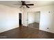 Bedroom with a ceiling fan, wood floors, mirrored closet doors, and an open door at 3514 W Altadena Ave, Phoenix, AZ 85029