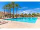 Community pool with palm trees, blue sky, and lounge chairs at 3552 E Carla Vista Dr, Gilbert, AZ 85295