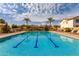 Sparkling community pool with palm trees, lounge chairs, and blue skies provides the perfect spot for relaxation and recreation at 3552 E Carla Vista Dr, Gilbert, AZ 85295