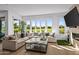 Open-concept living room with hardwood floors, a fireplace, and expansive windows offering views of lush landscaping at 37200 N Cave Creek Rd # 1122, Scottsdale, AZ 85262