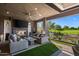 Stylish outdoor living room with a golf course view, sleek fireplace, and comfortable seating at 37200 N Cave Creek Rd # 1122, Scottsdale, AZ 85262
