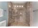 Tile shower with glass door, built-in seating, and decorative mosaic accents at 4525 E Desert View Dr, Phoenix, AZ 85044
