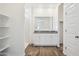 Bathroom with dual sinks, granite counters, and a glass-enclosed shower at 46378 W Lander Ln, Maricopa, AZ 85139