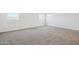 Bright bedroom featuring neutral carpet, white walls, and a window at 46378 W Lander Ln, Maricopa, AZ 85139