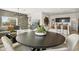 Modern dining area with a round table, stylish chairs, and a view of the open-concept living space at 46378 W Lander Ln, Maricopa, AZ 85139