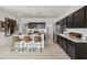 Modern kitchen with stainless steel appliances, marble countertops, and an island with bar seating at 46378 W Lander Ln, Maricopa, AZ 85139