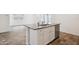 Kitchen island with granite countertop, stainless steel dishwasher, white cabinets, and an undermount sink at 46378 W Lander Ln, Maricopa, AZ 85139