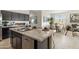Contemporary kitchen featuring stainless steel appliances, a marble countertop island, and open concept dining area at 46378 W Lander Ln, Maricopa, AZ 85139