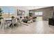 Bright living room with tile floors, modern lighting, and a sliding glass door to the backyard at 46378 W Lander Ln, Maricopa, AZ 85139