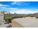 Landscaped backyard featuring a paved patio, lush shrubbery, and block wall fencing for privacy at 5237 W Alta Mesa Ave, Laveen, AZ 85339