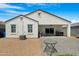 View of the home's backyard with hardscape patio, gravel landscaping, and covered patio at 5237 W Alta Mesa Ave, Laveen, AZ 85339