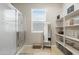 Bright bathroom featuring a walk-in shower, open shelves, and a window with natural light at 5237 W Alta Mesa Ave, Laveen, AZ 85339
