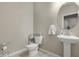 Charming half-bathroom with a modern pedestal sink, round mirror, and tiled floors at 5237 W Alta Mesa Ave, Laveen, AZ 85339
