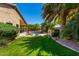 Expansive backyard oasis featuring a green lawn, mature landscaping, and a sparkling pool area for outdoor relaxation at 553 W Hereford Dr, San Tan Valley, AZ 85143