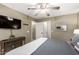 Bedroom featuring neutral walls, wood furniture, and an ensuite bathroom with a television for comfort and convenience at 553 W Hereford Dr, San Tan Valley, AZ 85143