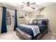 Comfortable bedroom featuring a rustic wood bed frame, neutral walls, and a window with blue curtains at 553 W Hereford Dr, San Tan Valley, AZ 85143