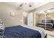 This bedroom has carpet, a fan, a bed with a blue comforter, a sliding door closet and a door to the bathroom at 553 W Hereford Dr, San Tan Valley, AZ 85143