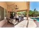 Inviting covered patio with stylish seating, a fire pit, and views of the lush backyard and pool area at 553 W Hereford Dr, San Tan Valley, AZ 85143