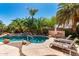 Beautiful backyard pool surrounded by lush, tropical landscaping and featuring a rock waterfall feature at 553 W Hereford Dr, San Tan Valley, AZ 85143