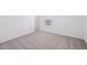 Bright bedroom with neutral carpet, white walls, a window, and an entry doorway at 5535 S 240Th Ln, Buckeye, AZ 85326