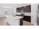 Contemporary kitchen features a large island, stainless steel appliances, and sleek dark cabinets at 5535 S 240Th Ln, Buckeye, AZ 85326