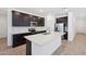 Modern kitchen features stainless steel appliances, a spacious island, and dark wood cabinetry at 5535 S 240Th Ln, Buckeye, AZ 85326