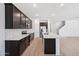 Modern kitchen features dark wood cabinets, stainless appliances, white countertops, and a spacious center island at 5535 S 240Th Ln, Buckeye, AZ 85326