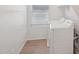 Bright laundry room with wood-look tile flooring, a window, and modern washer and dryer at 5535 S 240Th Ln, Buckeye, AZ 85326