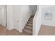 Carpeted staircase with white walls and railings leads to the upper level of the home at 5535 S 240Th Ln, Buckeye, AZ 85326