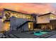 Modern home with a pool, outdoor staircase, and landscaped backyard with sunset views at 5814 E Camelback Rd, Phoenix, AZ 85018