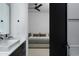 Modern bathroom transitioning into bedroom with sleek vanity, black fixtures and neutral decor at 5814 E Camelback Rd, Phoenix, AZ 85018