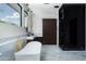 Modern bathroom with a soaking tub, glass shower, and sleek, dark wood cabinetry at 5814 E Camelback Rd, Phoenix, AZ 85018