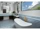 Beautiful bathroom with a modern soaking tub, marble countertops, and gold fixtures at 5814 E Camelback Rd, Phoenix, AZ 85018
